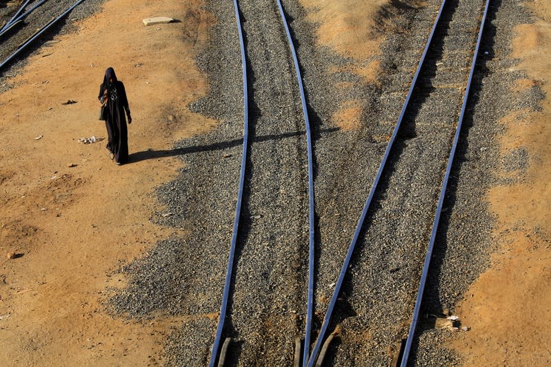A woman walks along the railway lines at the Atbara railway station in Nile State