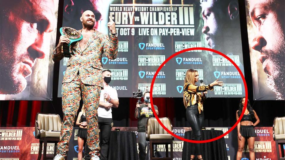 Tyson Fury (pictured left) poses with his belt as host Kate Abdo (pictured right) gestures on stage.