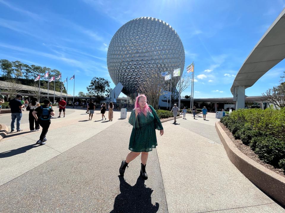 casey posing in front of the epcot ball at epcot in disney world