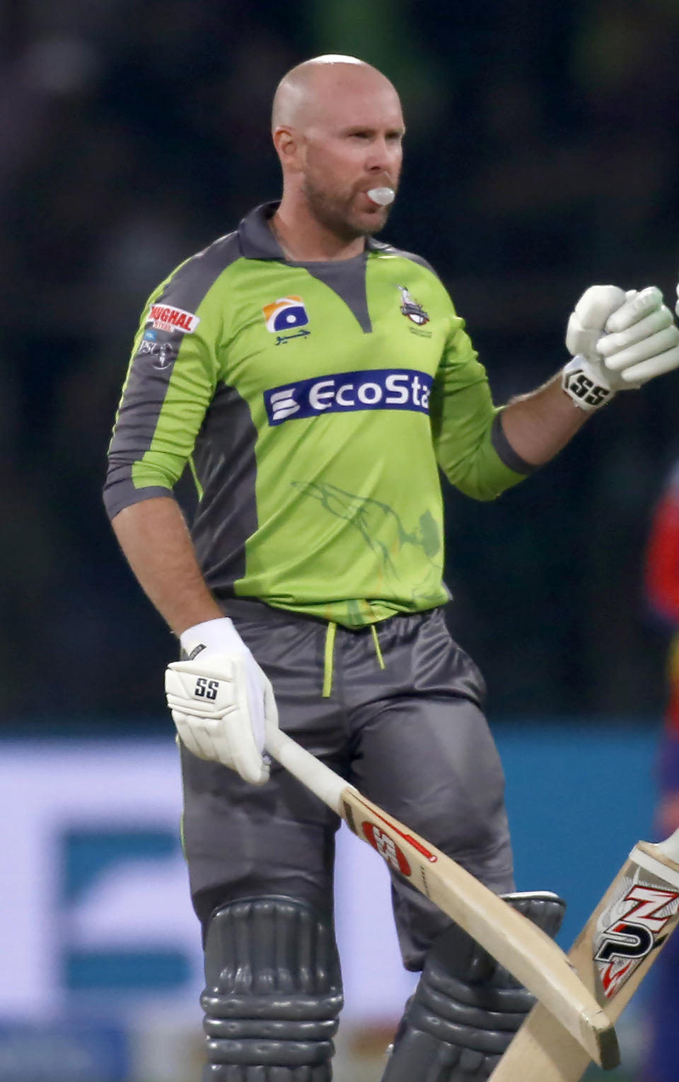 In this Sunday, March 8, 2020 photo, Lahore Qalandars batsmen Ben Dunk walks during a Pakistan Super League T20 cricket match against Karachi Kings, in Lahore, Pakistan. A bubble chewing bald Australian batsman has suddenly become an instant hit in the Pakistan Super League Twenty20 tournament. Dunk broke his own record of most sixes in a PSL game within a week when he smashed 12 towering sixes against Karachi Kings in a blistering knock of unbeaten 99 off just 40 balls on Sunday night. (AP Photo/K.M. Chaudary)