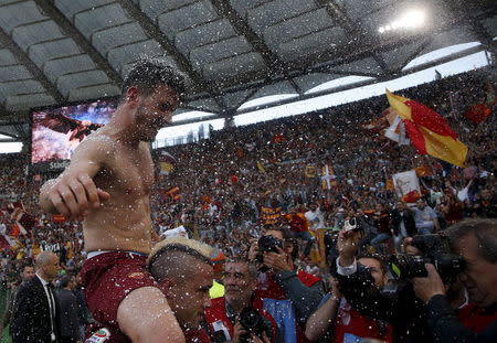 AS Roma's Alessandro Florenzi celebrates on the shoulder of his team mate Radja Nainggolan at the end of their Serie A soccer match against Lazio at the Olympic stadium in Rome, Italy, May 25, 2015. REUTERS/Alessandro Bianchi