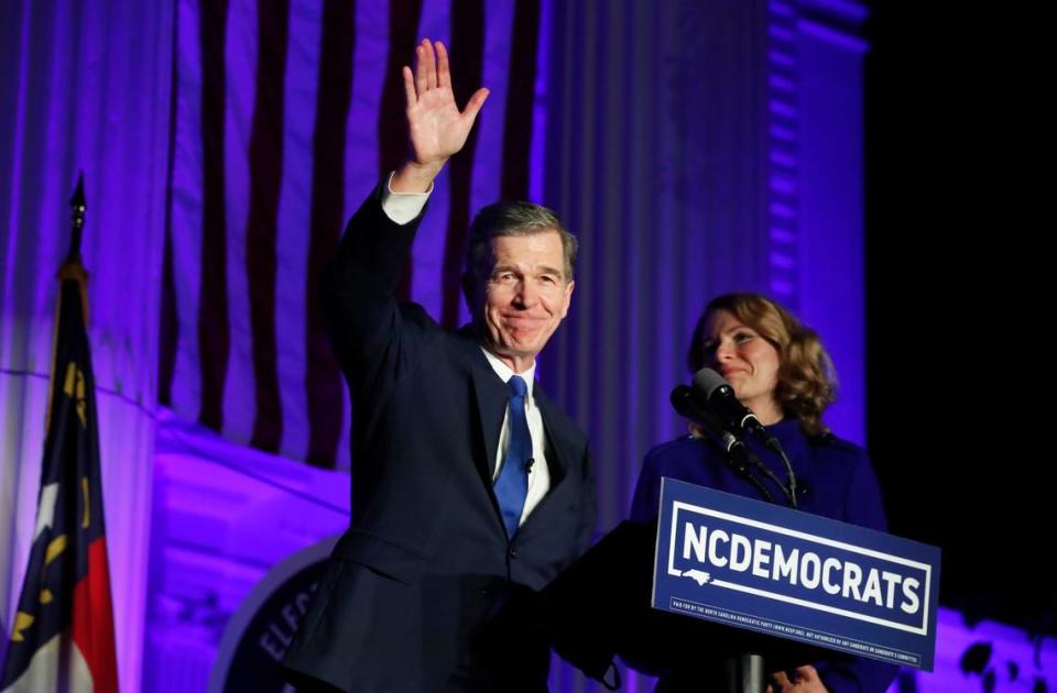 Gov. Roy Cooper waves after speaking outside the North Carolina Democratic Party headquarters in Raleigh in November 2020. Next to Cooper is his wife, Kristin Cooper.