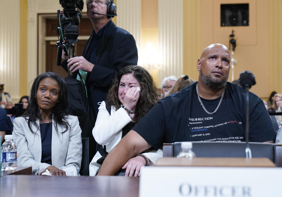 U.S. Capitol Police Sgt. Harry Dunn, right, Sandra Garza, the longtime partner of fallen Capitol Police Officer Brian Sicknick, center, and Serena Liebengood, widow of Capitol Police officer Howie Liebengood, left, react as a video of the Jan. 6 attack on the U.S. Capitol is played during a public hearing of the House select committee investigating the attack is held on Capitol Hill, Thursday, June 9, 2022, in Washington. (AP Photo/Andrew Harnik)