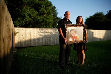 Kelly and Ryan Breaux stand holding a portrait of their deceased daughter Emma Breaux, at their home in Breaux Bridge, Louisiana, on June 16, 2016. The husband and wife lost twins, Emma and Talon, to different superbugs that they contracted while in the neonatal unit at Lafayette General Hospital. U.S. Picture taken June 16, 2016. REUTERS/Edmund Fountain