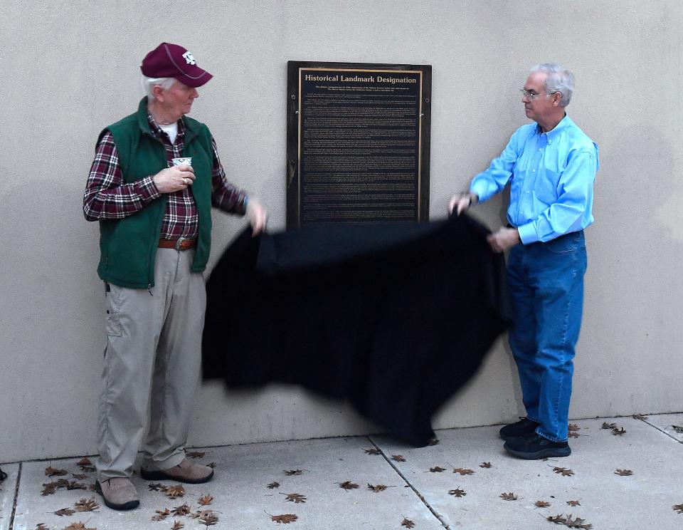 Tom McAlister (left) and Jerry Love reveal a historical plaque during a ceremony at Safety City.