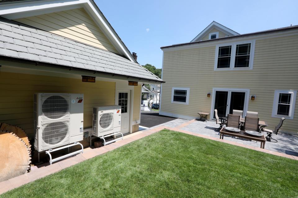 Heat pumps operate outside Kevin Fleming's home in Pelham July 19, 2022. Fleming took advantage of a Con Edison offer for rebates if he installed heat pumps in his home. Heat pumps are energy efficient devices that can produce both heat in the winter and air conditioning in summer. Fleming says his system produces more energy than his home uses.