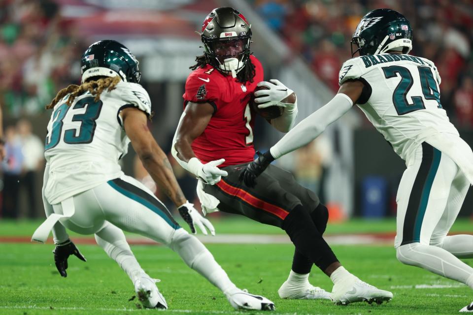 Jan 15, 2024; Tampa, Florida, USA; Tampa Bay Buccaneers running back <a class="link " href="https://sports.yahoo.com/nfl/players/34047" data-i13n="sec:content-canvas;subsec:anchor_text;elm:context_link" data-ylk="slk:Rachaad White;sec:content-canvas;subsec:anchor_text;elm:context_link;itc:0">Rachaad White</a> (1) runs the ball as Philadelphia Eagles cornerbacks <a class="link " href="https://sports.yahoo.com/nfl/players/27559" data-i13n="sec:content-canvas;subsec:anchor_text;elm:context_link" data-ylk="slk:Bradley Roby;sec:content-canvas;subsec:anchor_text;elm:context_link;itc:0">Bradley Roby</a> (33) and <a class="link " href="https://sports.yahoo.com/nfl/players/29296" data-i13n="sec:content-canvas;subsec:anchor_text;elm:context_link" data-ylk="slk:James Bradberry;sec:content-canvas;subsec:anchor_text;elm:context_link;itc:0">James Bradberry</a> (24) defend during the first half of a 2024 NFC wild card game at Raymond James Stadium. Mandatory Credit: Kim Klement Neitzel-USA TODAY Sports
