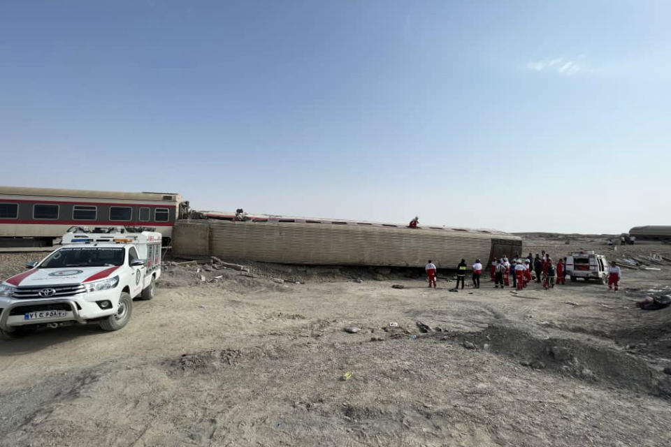 This photo provided by the Iranian Red Crescent Society shows the scene where a passenger train was partially derailed near the desert city of Tabas in eastern Iran, Wednesday, Iran, Wednesday, June 8, 2022. (Iranian Red Crescent Society via AP)
