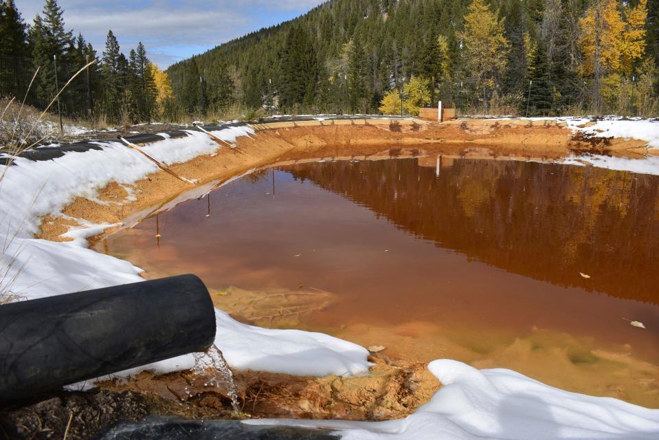 Water contaminated with arsenic, lead and zinc flows from a pipe out of the Lee Mountain mine and into a holding pond near Rimini, Mont. on Oct. 12, 2018.  The community is part of the Upper Tenmile Creek Superfund site, where dozens of abandoned mines have left water supplies polluted and residents must use bottled water.