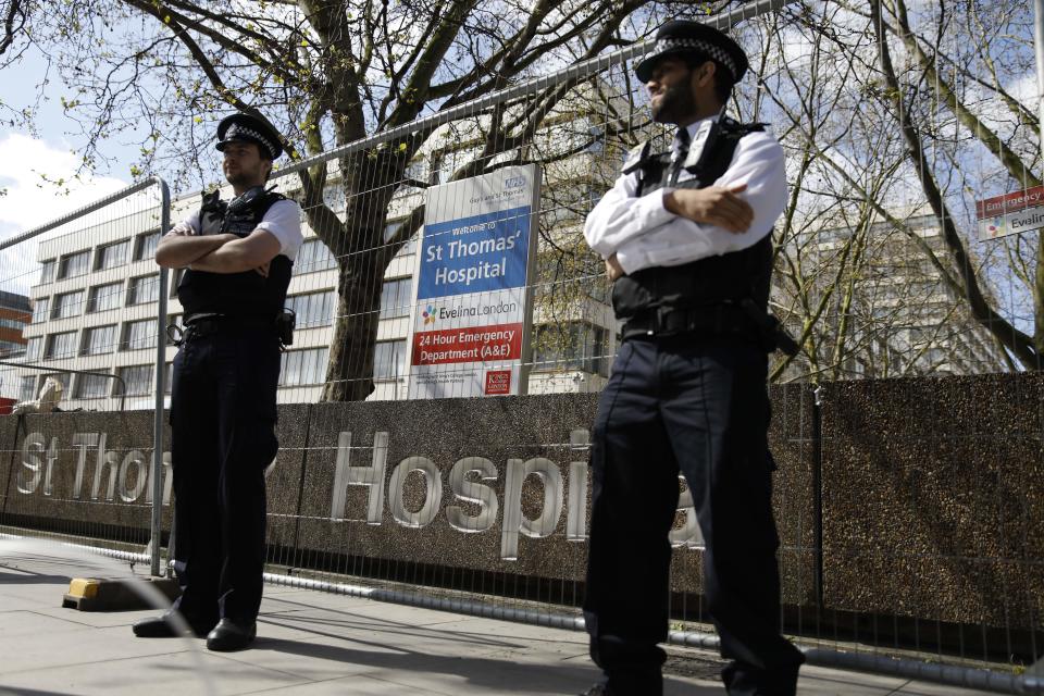 Police officers stand in front of barriers erected outside St Thomas' Hospital in London on April 6, 2020. - British Prime Minister Boris Johnson was in hospital on Monday undergoing tests after suffering "persistent" symptoms of coronavirus for 10 days, but colleagues insisted he remains in charge of the government. Reports have suggested that the prime minister was admitted to nearby St Thomas' Hospital last night. (Photo by Tolga AKMEN / AFP) (Photo by TOLGA AKMEN/AFP via Getty Images)