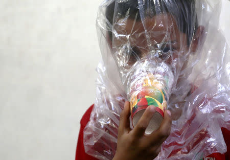 A boy tries on an improvised gas mask in Idlib, Syria September 3, 2018. Picture taken September 3, 2018. REUTERS/Khalil Ashawi