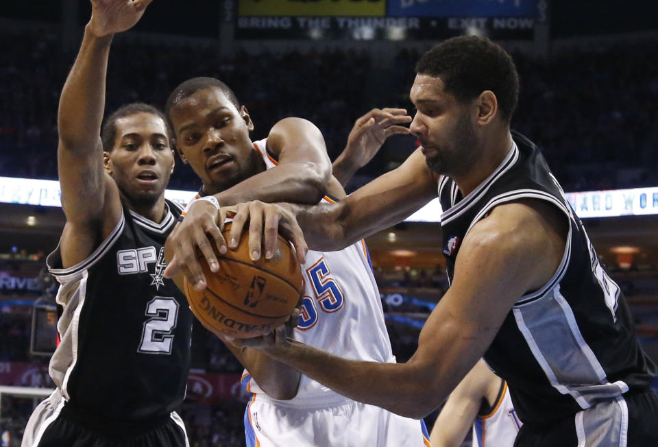 Oklahoma City Thunder forward Kevin Durant (35) and San Antonio Spurs forward Tim Duncan, right, vie for control of the ball in front of Spurs forward Kawhi Leonard (2) during the first quarter of an NBA basketball game in Oklahoma City, Thursday, April 3, 2014. (AP Photo/Sue Ogrocki)