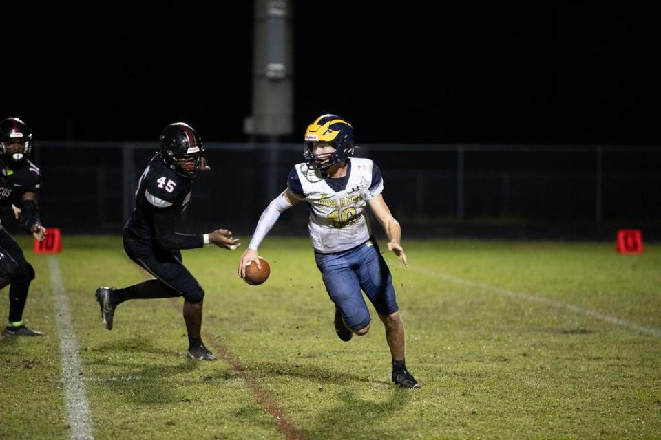 Boca Raton quarterback Chance Routson scrambles against Palm Beach Central on Nov. 17, 2023.