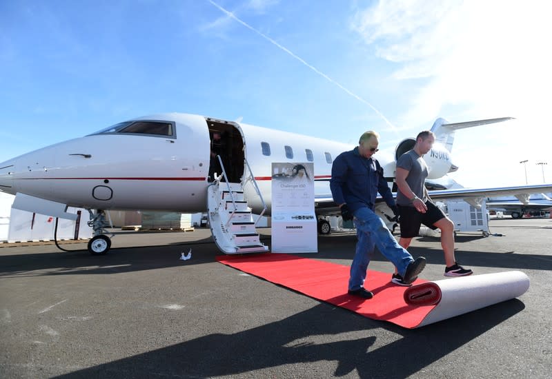 Workers roll out the red carpet for a Challenger 650 business jet at the Bombardier booth at the National Business Aviation Association (NBAA) exhibition in Las Vegas