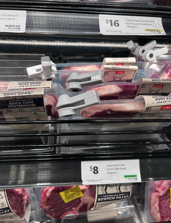 Coles meat on shelf pictured with individual security tags.