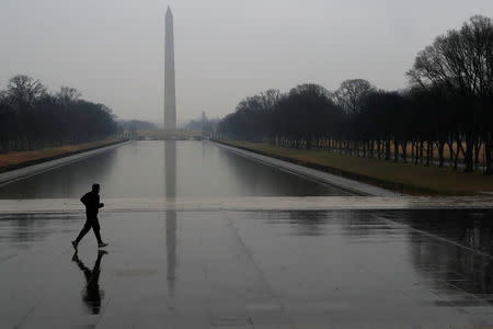 A jogger runs through the rain past the reflecting pool at the Lincoln Memorial in Washington, U.S., February 7, 2018. REUTERS/ Leah Millis