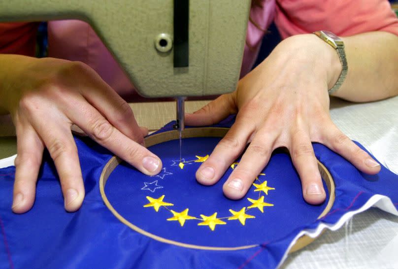 Eine Näherin stickt die Sterne auf eine EU-Flagge in Budapest, April 2003