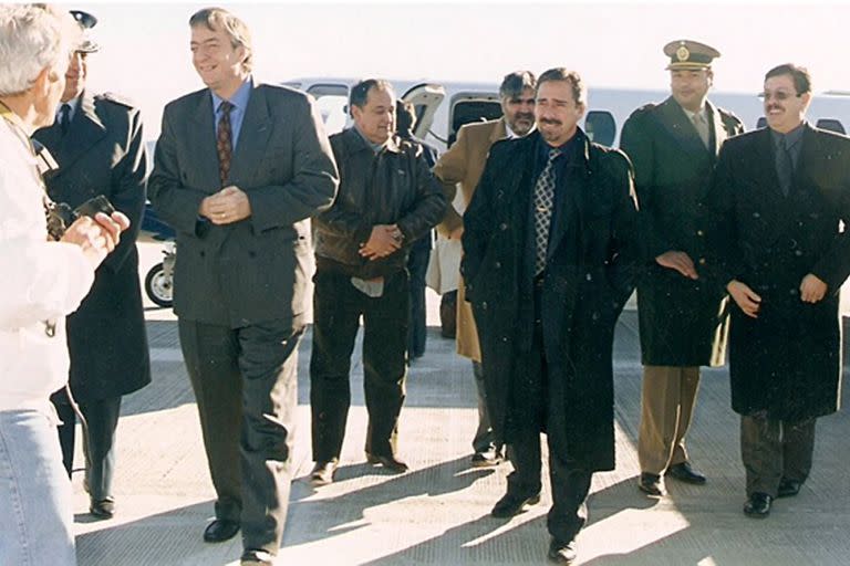 Kirchner desce do avião em Santa Cruz em 1999, seguido por Ricardo Jaime e Raúl Copetti (de óculos escuros)