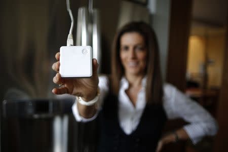 Computer science professor Christa Lopes holds an appliance communication module attached to the refrigerator in her home in Irvine, California January 26, 2015. REUTERS/Lucy Nicholson