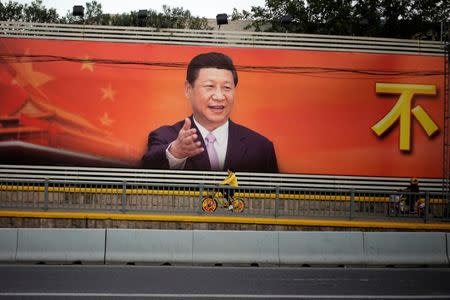 A poster with a portrait of Chinese President Xi Jinping is displayed along a street in Shanghai, China, October 24, 2017. REUTERS/Aly Song
