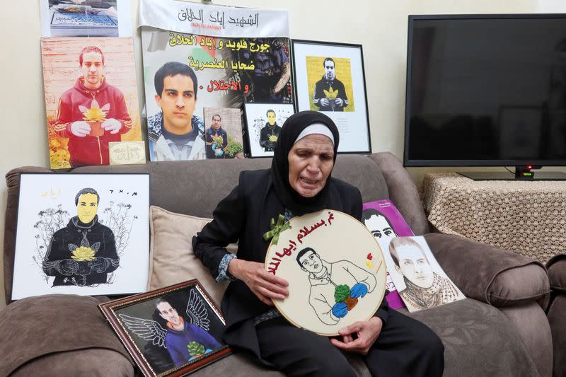 Rana al-Halaq, the mother of Iyad al-Halaq, an unarmed autistic Palestinian man who was shot dead by Israeli police, sits surrounded by pictures of her son in her family home in East Jerusalem