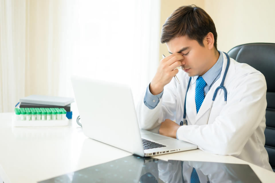 A doctor with his hand over his head looking upset