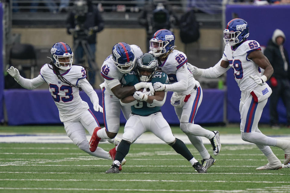 New York Giants defenders tackle Philadelphia Eagles' Boston Scott, center, during the first half of an NFL football game, Sunday, Nov. 28, 2021, in East Rutherford, N.J. (AP Photo/Corey Sipkin)