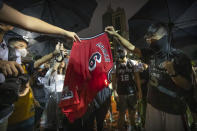 Demonstrators set a Lebron James jersey on fire during a rally at the Southorn Playground in Hong Kong, Tuesday, Oct. 15, 2019. Protesters in Hong Kong have thrown basketballs at a photo of LeBron James and chanted their anger about comments the Los Angeles Lakers star made about free speech during a rally in support of NBA commissioner Adam Silver and Houston Rockets general manager Daryl Morey, whose tweet in support of the Hong Kong protests touched off a firestorm of controversy in China. (AP Photo/Mark Schiefelbein)