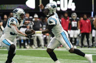 Carolina Panthers kicker Ryan Santoso (9) hands the ball to Carolina Panthers running back Chuba Hubbard (30) during the second half of an NFL football game against the Atlanta Falcons, Sunday, Oct. 31, 2021, in Atlanta. (AP Photo/Mark Humphrey)