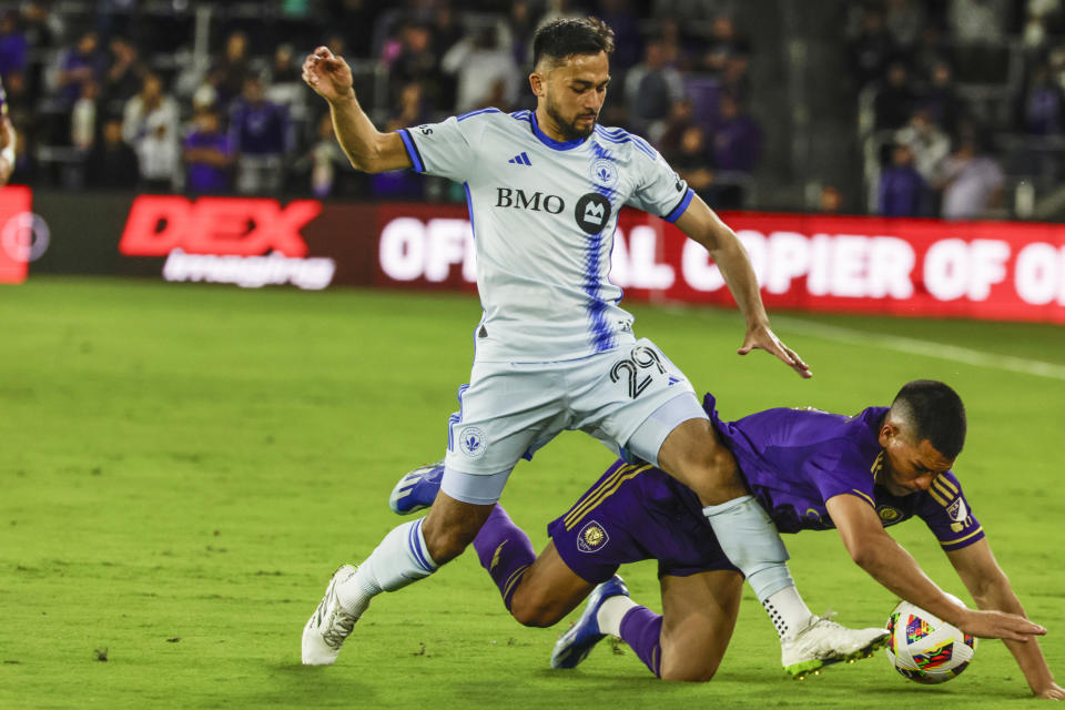 Orlando City midfielder César Araújo, right, and CF Montréal midfielder Mathieu Choinière, left, vie for the ball during the second half of an MLS soccer match Saturday, Feb. 24, 2024, in Orlando, Fla. (AP Photo/Kevin Kolczynski)