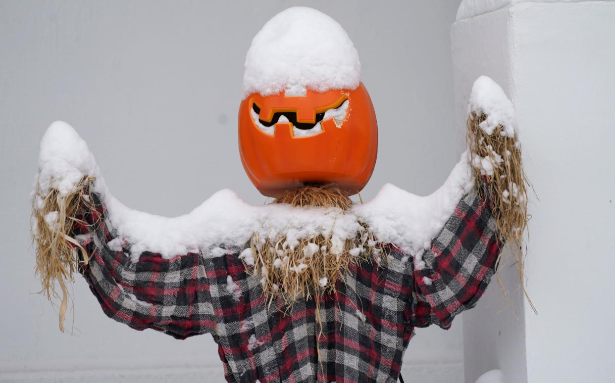 Snow covers a Halloween character in a lawn display after an autumn storm swept over the intermountain West on Oct. 26, 2020, in Denver.