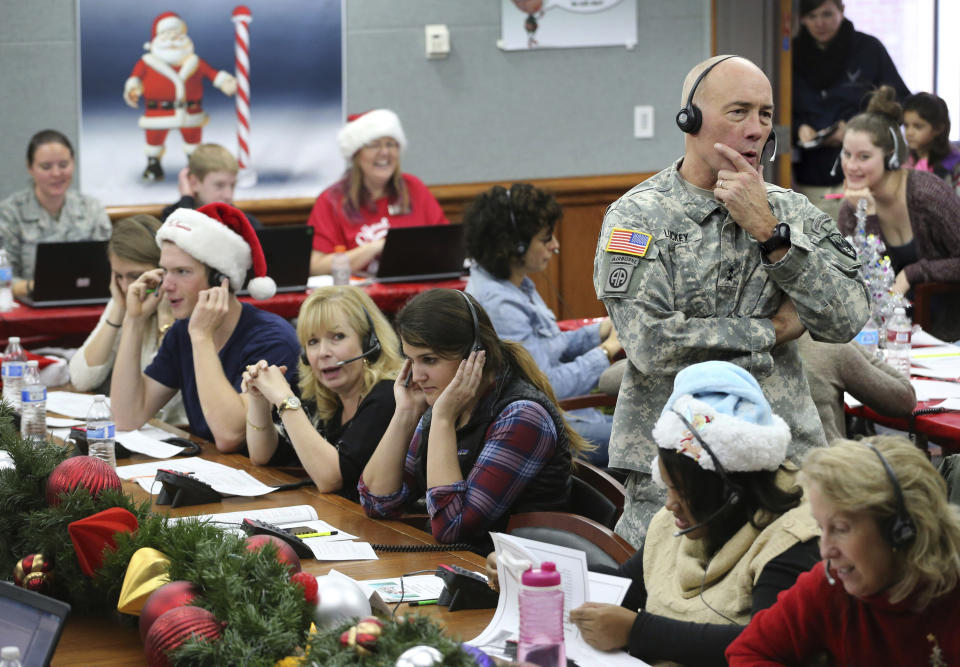 FILE - In this Dec. 24, 2014, file photo, NORAD Chief of Staff Maj. Gen. Charles D. Luckey takes a call while volunteering at the NORAD Tracks Santa center at Peterson Air Force Base in Colorado Springs, Colo. Hundreds of volunteers will help answer the phones from children around the world calling for Santa when the program resumes on Monday, Dec. 24, 2018, for the 63rd year. (AP Photo/Brennan Linsley, File)