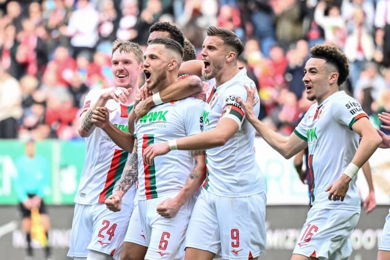 (L-R) Augsburg's Fredrik Jensen, goal scorer Jeffrey Gouweleeuw, Ermedin Demirovic and Ruben Vargas celebrate their side's first goal of the game during the German Bundesliga soccer match between FC Augsburg and 1. FC Heidenheim at WWK Arena. Harry Langer/dpa