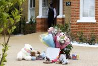 Flowers and toys are seen outside a house where the bodies of three children were found, in New Malden, southwest London April 23, 2014. A 43-year-old woman has been arrested on suspicion on murder after the bodies of three children were found at a house in southwest London, police said on Wednesday. Police said a four-year-old girl and two boys, both aged three, were found dead at a residential address in New Malden on Tuesday evening. REUTERS/Olivia Harris (BRITAIN - Tags: CRIME LAW SOCIETY TPX IMAGES OF THE DAY)