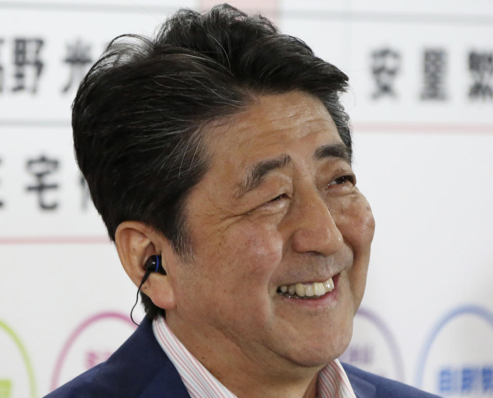 Japan's Prime Minister Shinzo Abe, leader of the Liberal Democratic Party, smiles during a TV interview at the party headquarters in Tokyo, Sunday, July 21, 2019. Exit polls have showed Prime Minister Shinzo Abe's ruling coalition is certain to keep the majority of 124 seats contested in Sunday's upper house election, and could go even closer to the super-majority, the key line needed to propose a constitutional revision if joined by supporters from smaller parties. (AP Photo/Koji Sasahara)