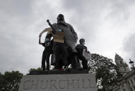 Protesters stand on the statue of former British Prime Minister Winston Churchill during a demonstration in Parliament Square in London on Wednesday, June 3, 2020, over the death of George Floyd, a black man who died after being restrained by Minneapolis police officers on May 25. Protests have taken place across America and internationally, after a white Minneapolis police officer pressed his knee against Floyd's neck while the handcuffed black man called out that he couldn't breathe. The officer, Derek Chauvin, has been fired and charged with murder. (AP Photo/Kirsty Wigglesworth)