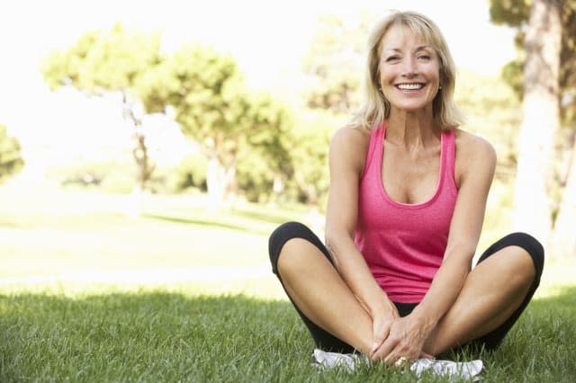 Senior Woman Resting After Exercising In Park