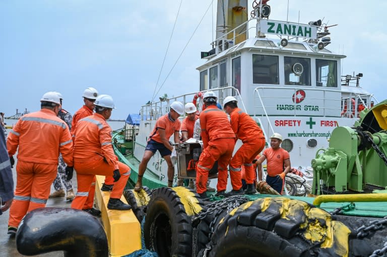 Personal de la Guardia Costera de Filipinas carga el material para contener un derrame de petróleo tras el hundimiento de un buque de carga en Limay, cerca de Manila, el 26 de julio de 2024 (Jam Sta Rosa)