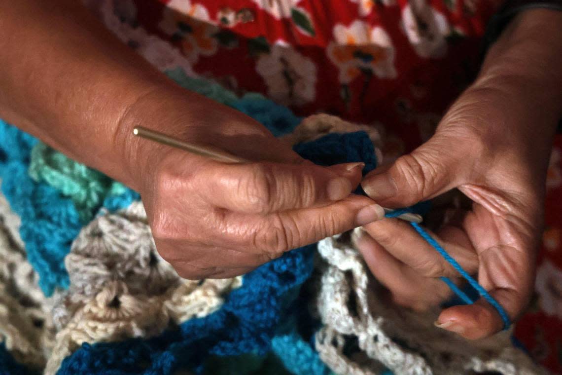 Angela Phang, 71, a client of Miami Lighthouse for the Blind, nimbly crochets on Tuesday, Oct. 1, 2022. Her fabrics bring joy to their recipients, whom Phang most often never gets to meet.