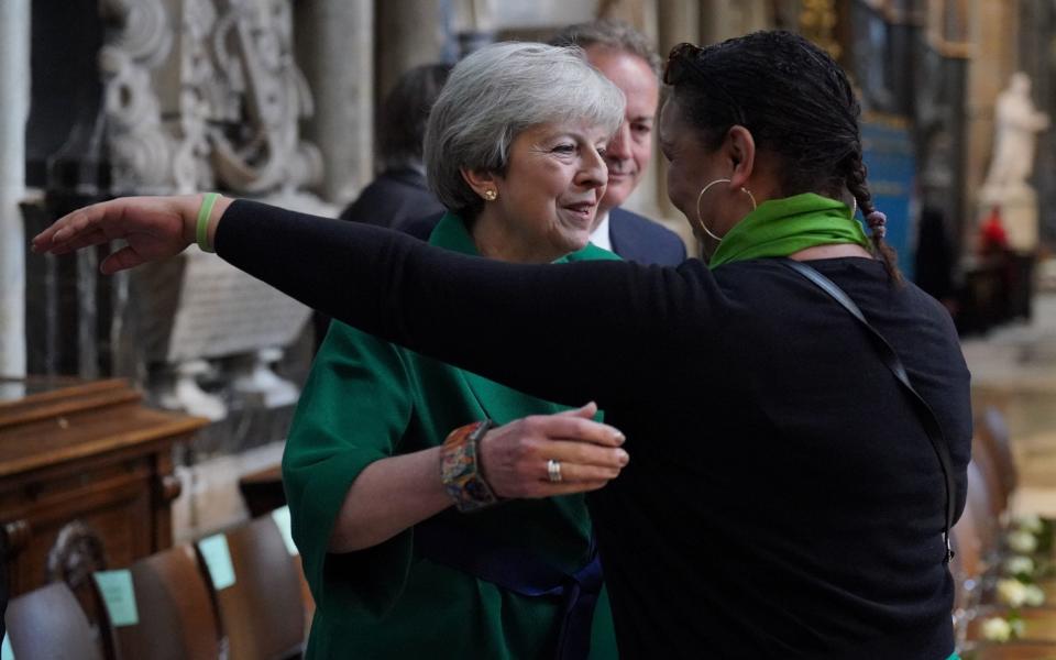 Theresa May is embraced by community volunteer Claire Walker at the memorial service - Jonathan Brady/PA