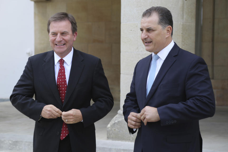 ExxonMobil Senior Vice President Neil Chapman, left, and Cyprus' Energy Minister Georgios Lakkotrypis leave, after a meeting with Cyprus' president Nicos Anastasiades at the presidential palace in capital Nicosia, Cyprus, Friday Oct. 5, 2018. A top ExxonMobil executive says the energy company will go ahead with a search for natural gas off the cost of Cyprus by the end of the year. (AP Photo/Petros Karadjias)