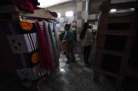 Iracema Figueroa, left, of Honduras, waits for her turn to take a shower at a shelter for migrants Friday, May 20, 2022, in Tijuana, Mexico. Figueroa has spent two years trying to reach a safe place for her family and was praying the judge would lift the order. Figueroa left Honduras in 2019 after gangs killed her uncle and threatened her three sons. (AP Photo/Gregory Bull)