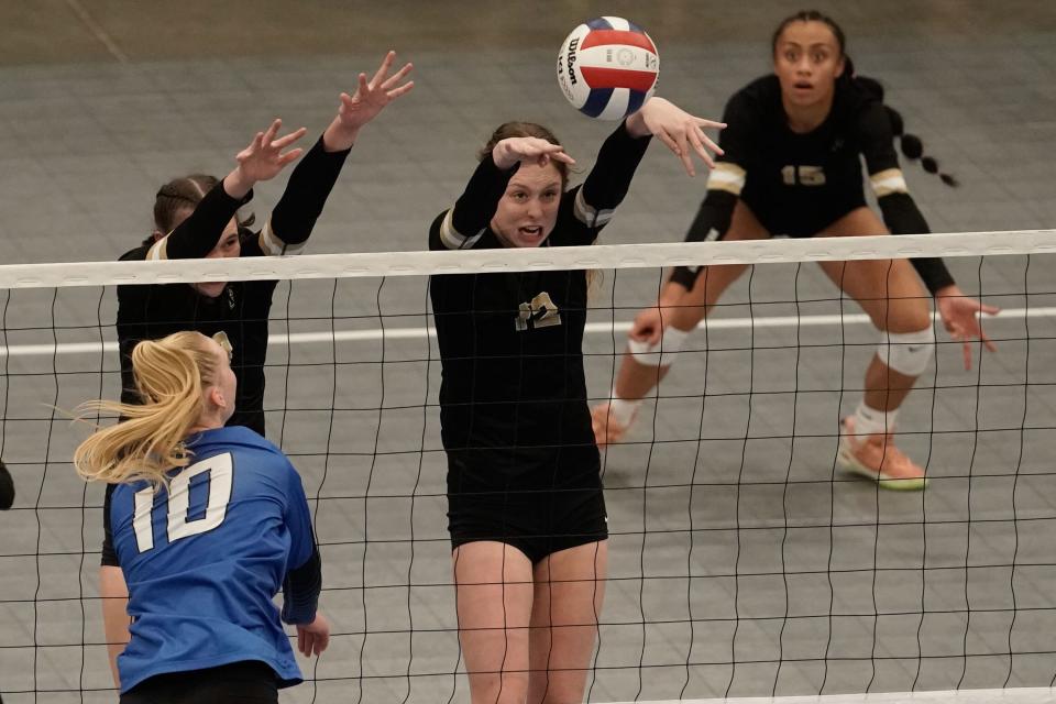 Lone Peak’s Zoey Burgess, left, and Kelli Jo Burgess block a shot by Pleasant Grove’s Ashley Gneiting (10) in the 6A volleyball state championship at the UCCU Center in Orem on Saturday, Nov. 6, 2021. | Shafkat Anowar, Deseret News