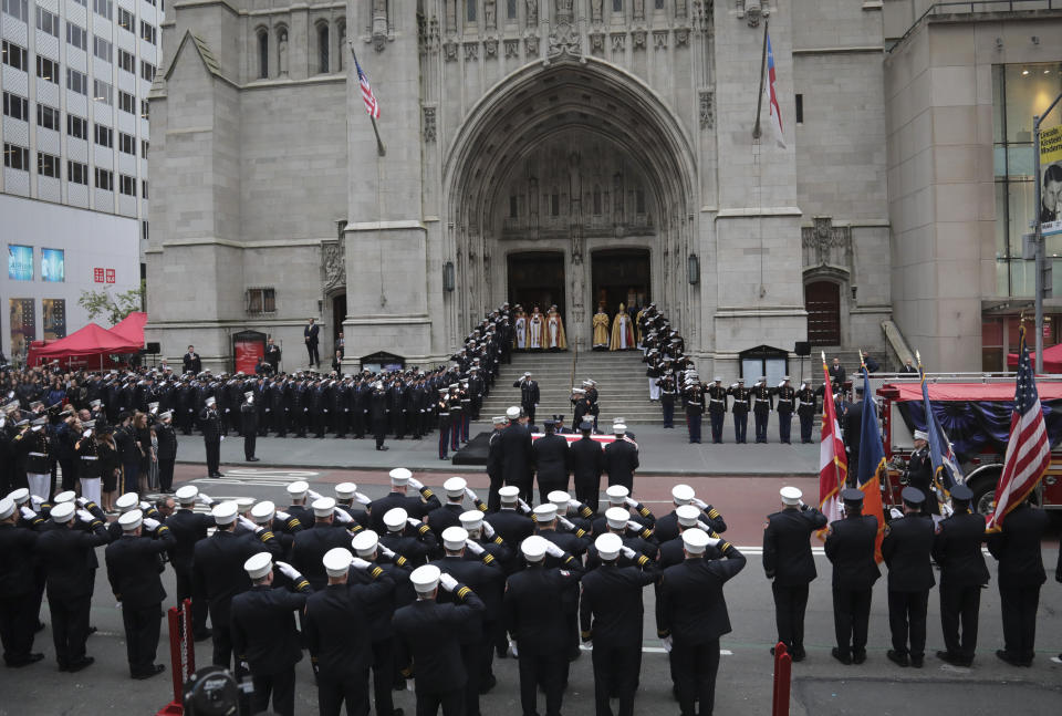 The casket of U.S. Marine Corps Staff Sergeant and FDNY Firefighter Christopher Slutman, center, arrives for his funeral service at St. Thomas Episcopal Church, Friday April 26, 2019, in New York. The father of three died April 8 near Bagram Airfield U.S military base in Afghanistan. (AP Photo/Bebeto Matthews)