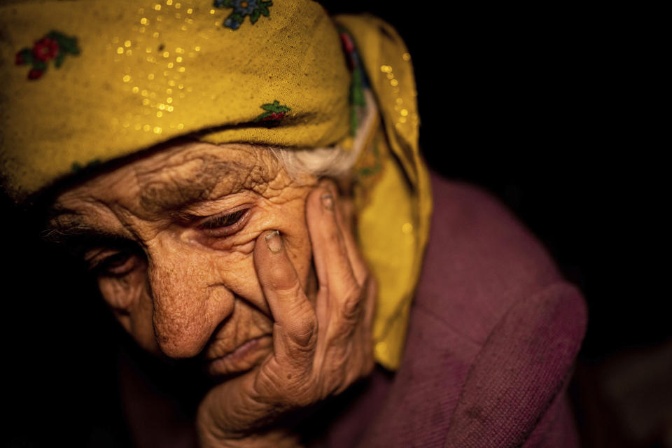 Nina Gonchar, 93, sits in her house which was mostly destroyed by Russian forces in the recently retaken village of Bogorodychne, Ukraine, Saturday, Jan. 7, 2022. Gonchar's son Vasyliy and his wife Liubov were killed by Russian shelling on July 10, 2022. (AP Photo/Evgeniy Maloletka)