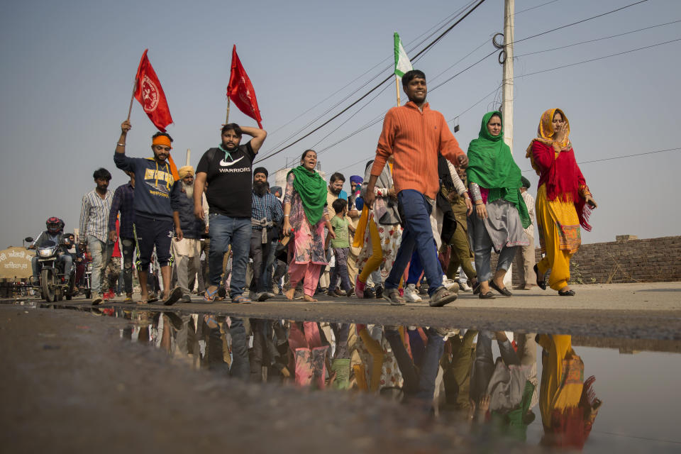 A group of protesters shout slogans as they arrive to join farmers demanding to abolish new farming laws they say will result in exploitation by corporations, eventually rendering them landless, at the Delhi-Haryana state border, India, Tuesday, Dec. 1, 2020. The busy, nonstop, arterial highways that connect most northern Indian towns to this city of 29 million people, now beat to the rhythm of never-heard-before cries of "Inquilab Zindabad" ("Long live the revolution"). Tens and thousands of farmers, with colorful distinctive turbans and long, flowing beards, have descended upon its borders where they commandeer wide swathes of roads. (AP Photo/Altaf Qadri)