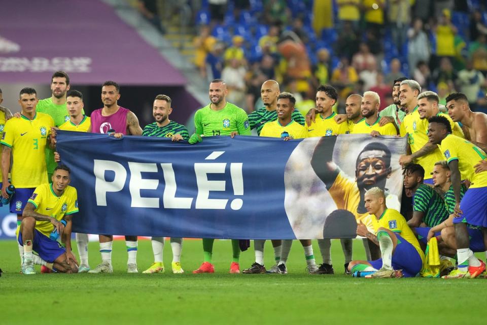 Brazil’s players hold up a Pele banner on the pitch after their win over South Korea (Martin Rickett/PA). (PA Wire)