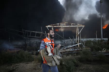 A Palestinian firefighter reacts as he tries to put out a fire at Gaza's main power plant, which witnesses said was hit in Israeli shelling, in the central Gaza Strip July 29, 2014. REUTERS/Mohammed Salem