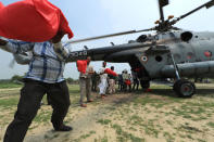 <p>Flood affected villagers queue up to unload relief material from Indian Air Force helicopter on the outskirts of Allahabad, India, Friday, Aug. 26, 2016. (AP Photo/Rajesh Kumar Singh)</p>