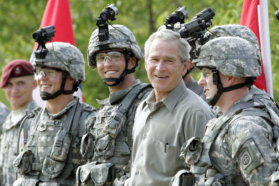 FILE - President George W. Bush smiles as he poses for a group photo with military personnel during his visit to U.S. Army Special Operations Command at Fort Bragg, N.C., July 4, 2006. (AP Photo/Pablo Martinez Monsivais, File)